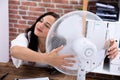 Woman Enjoying Breeze With Electric Fan