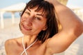 Smiling young woman enjoying her holiday on the beach. Satisfied beautiful girl relaxes on the beach during sunrise Royalty Free Stock Photo