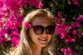 Smiling young woman with flower in hair on blooming bush background Royalty Free Stock Photo