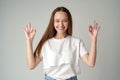 Smiling young woman gesturing ok sign against gray background Royalty Free Stock Photo