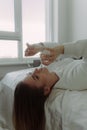 Smiling young woman girl puts on glasses while lying in bed spending time in bedroom at home. Rest mood lifestyle concept Royalty Free Stock Photo