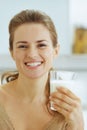 smiling young woman with glass of milk in kitchen Royalty Free Stock Photo