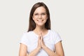 Smiling millennial girl with prayer hands feel thankful