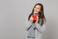 Smiling young woman in gray sweater, scarf holding red cup of coffee or tea isolated on grey wall background. Healthy Royalty Free Stock Photo
