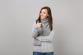 Smiling young woman in gray sweater, scarf pointing index finger on camera on grey wall background. Healthy Royalty Free Stock Photo