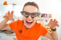 Smiling young woman in Halloween decorated kitchen frightening