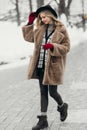 Smiling young woman hat coat outside flowers bouquet yellow joy gift blonde model Royalty Free Stock Photo