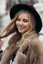 Smiling young woman hat coat outside flowers bouquet yellow joy gift blonde model Royalty Free Stock Photo