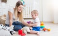 Smiling young woman with her baby son playing with toy mobile phone Royalty Free Stock Photo