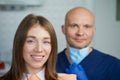 A smiling young woman with her bald middle-aged dentist in a dentist`s office Royalty Free Stock Photo