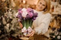 Smiling young woman holding a bouquet of tender pink and purple color flowers with green stalks Royalty Free Stock Photo