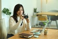 Smiling woman holding camera and checking picture previews. Royalty Free Stock Photo
