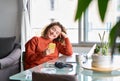 Smiling young woman holding cell phone using smartphone at home. Royalty Free Stock Photo