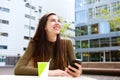 Smiling young woman holding cellphone with coffee Royalty Free Stock Photo