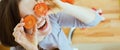 Smiling woman holding cherry tomatos in front of face Royalty Free Stock Photo