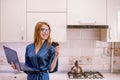 Smiling young woman holding credit card and blue laptop computer in hands Royalty Free Stock Photo