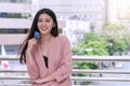 Smiling woman holding a credit card in city background. Attractive business woman get satisfy and happy with freedom of