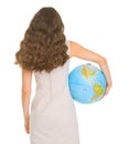 Smiling young woman holding globe. Rear view Royalty Free Stock Photo