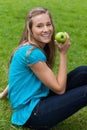 Smiling young woman holding a green apple Royalty Free Stock Photo