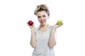 Smiling young woman holding green and red apples in her hands. Beautiful blonde in a gray polo. Healthy food, vegetarianism and Royalty Free Stock Photo