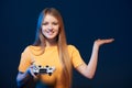 Smiling young woman holding joystick looking at camera