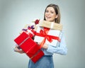 Smiling young woman holding pile of gifts.