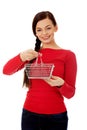 Smiling young woman holding small empty shopping cart Royalty Free Stock Photo