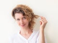 Smiling young woman holding strand of her curly hair Royalty Free Stock Photo