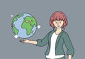 Smiling young woman holding a terrestrial globe or globe over her hand. A girl teacher in geography shows the device of the planet