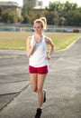 Smiling young woman jogging, training outdoors Royalty Free Stock Photo