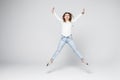 Happiness, freedom, power, motion and people concept - smiling young woman jumping in air with raised fists over white background Royalty Free Stock Photo