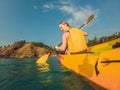 Smiling young woman kayaking on sea. Happy young woman canoeing in sea on a summer day Royalty Free Stock Photo