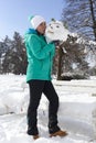 Smiling young woman kissing a snowman head Royalty Free Stock Photo