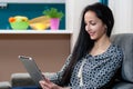 Smiling young woman laying on couch and using laptop Royalty Free Stock Photo