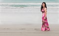Smiling young woman in long dress on the ocean shore Royalty Free Stock Photo