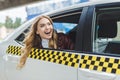 smiling young woman looking away through taxi window