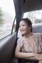 Smiling Young Woman Looking Out Window In Taxi, motion blur