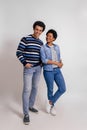 Smiling young woman looking romantically at boyfriend while posing together on white background