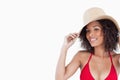 Smiling young woman looking straight at the camera while holding her straw hat against a white background Royalty Free Stock Photo