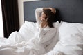 Happy young woman lying in bed talking on cell Royalty Free Stock Photo