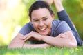 Smiling young woman lying outdoors on grass Royalty Free Stock Photo