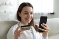 Smiling young woman make online payment with credit card Royalty Free Stock Photo