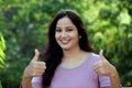 Smiling young woman making thumbs up gesture Royalty Free Stock Photo