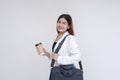 A smiling young woman with messenger bag and holding to-go coffee cup posing in front of the camera. Isolated on a white Royalty Free Stock Photo