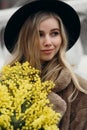 Smiling young woman with mimosa flowers International Women& x27;s Day. Royalty Free Stock Photo