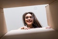 Smiling young woman opening a carton box, relocation and unpacking concept Royalty Free Stock Photo