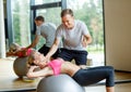 Smiling young woman with personal trainer in gym Royalty Free Stock Photo
