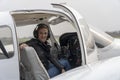 Smiling Young Woman Pilot With Headset Sitting in Cockpit of Private Aircraft Royalty Free Stock Photo