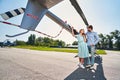 Romantic couple standing by private chopper parked on helipad