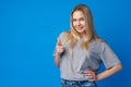 Smiling young woman pointing at copy space over blue background Royalty Free Stock Photo